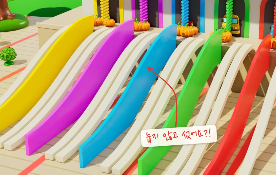 다섯 색 미끄럼틀이 경사면으로 눕지 않고 지느러미처럼 세로로 서 있는 장면. 서 있는 미끄럼틀에 화살표 메모